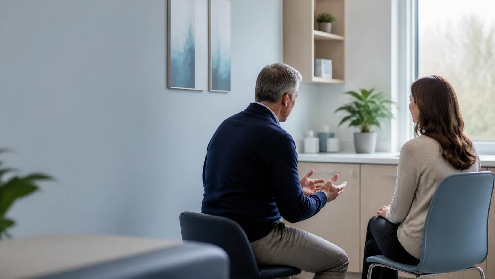 A healthcare professional speaking with a patient in a bright medical clinic